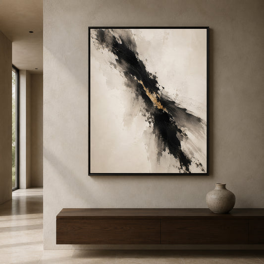 A framed abstract wall art print hangs on a textured beige wall above a dark wood console table. The artwork features a diagonal black and gray brushstroke pattern with a small gold accent on a warm off-white background.