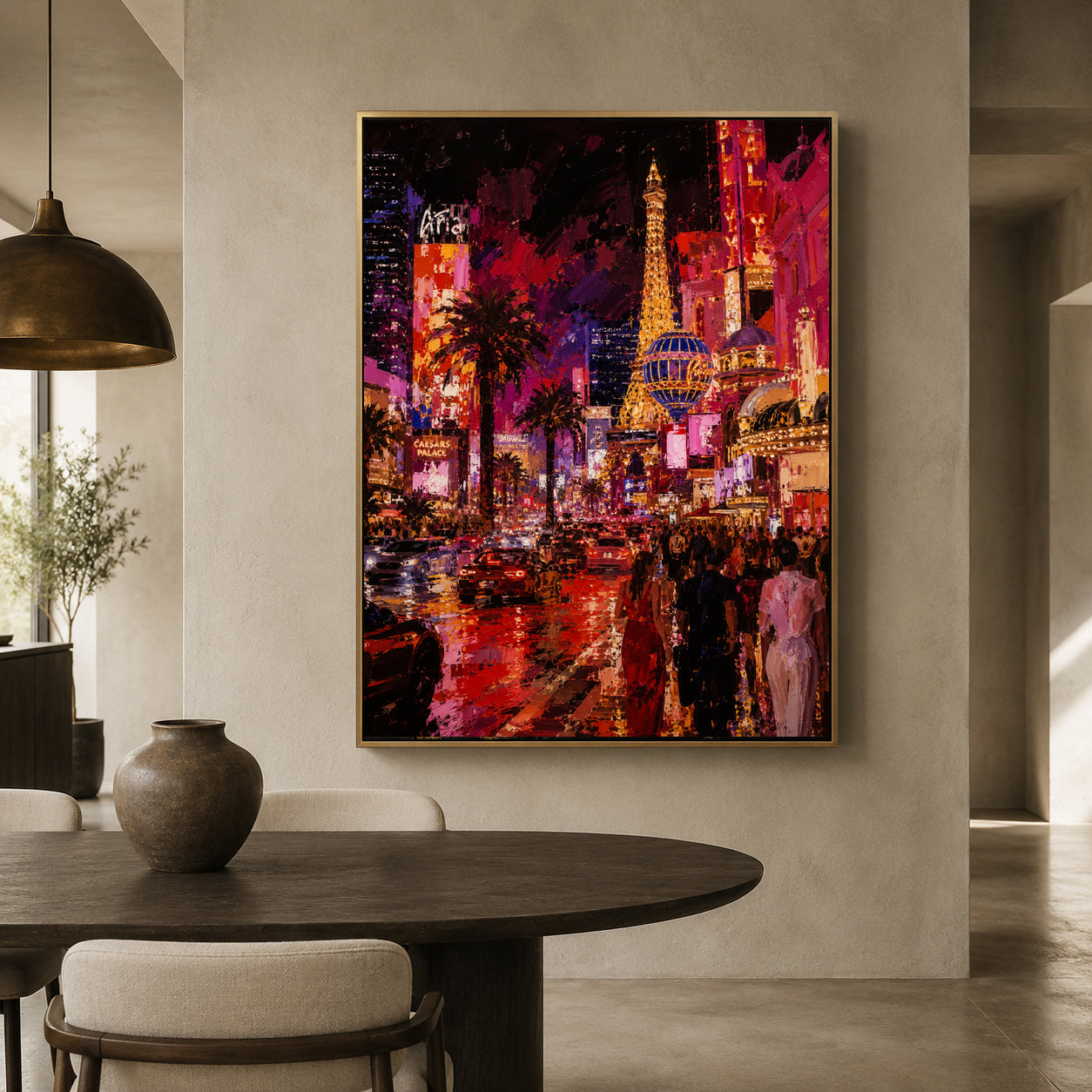 A large framed canvas print of a vibrant Las Vegas cityscape painting hangs on a beige wall in a modern dining room setting with a dark wood table and chairs.