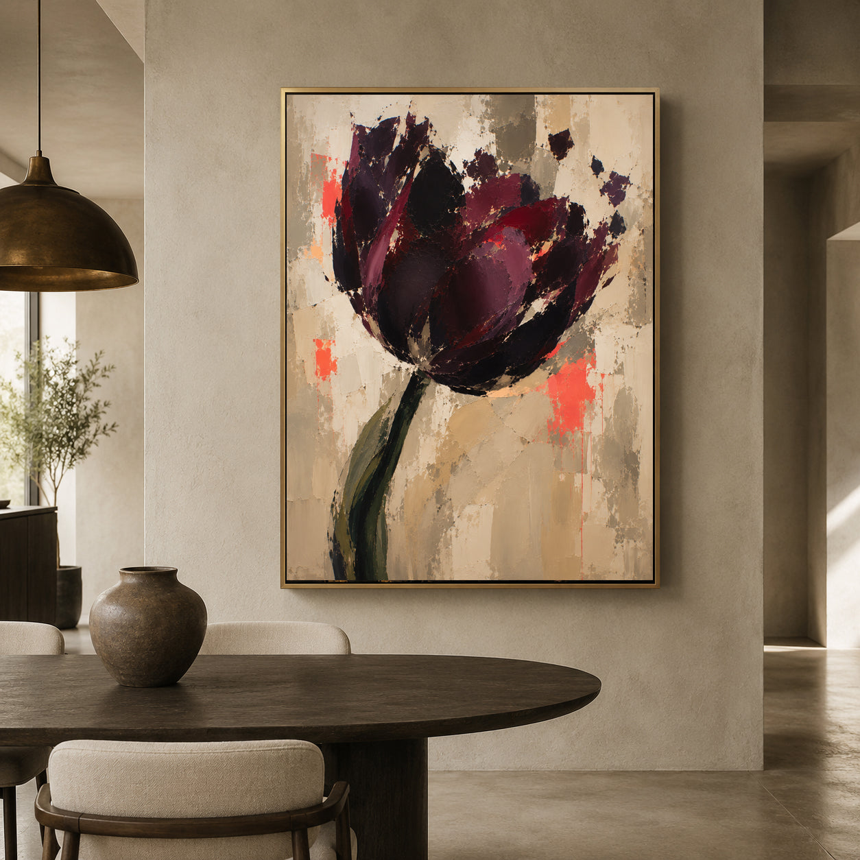 A framed abstract floral painting hangs on a beige wall above a dark wood dining table in a modern interior. The artwork depicts a large dark purple and burgundy flower with green and coral accents on a warm beige background.