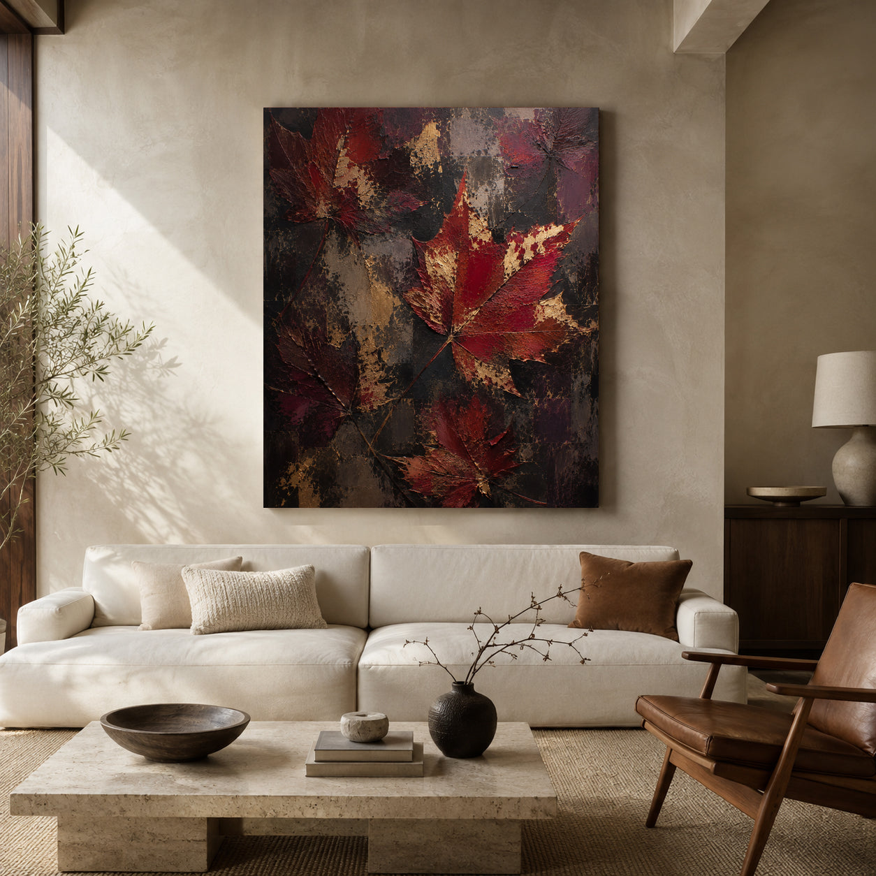 A large vertical canvas print featuring abstract red and gold maple leaves on a dark textured background, displayed on a beige wall above a modern white sofa in a styled living room.