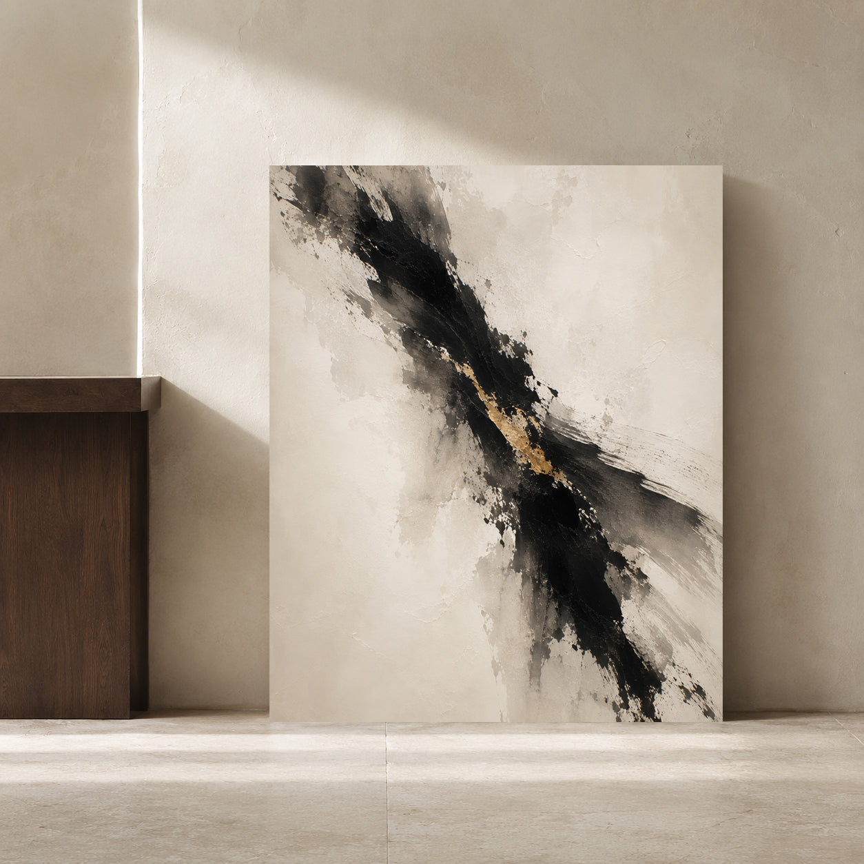 Abstract canvas wall art leaning against a textured beige wall in a minimalist interior setting. The artwork features a diagonal composition with bold black and gray brushstrokes and a shimmering gold accent line on a warm off-white background.