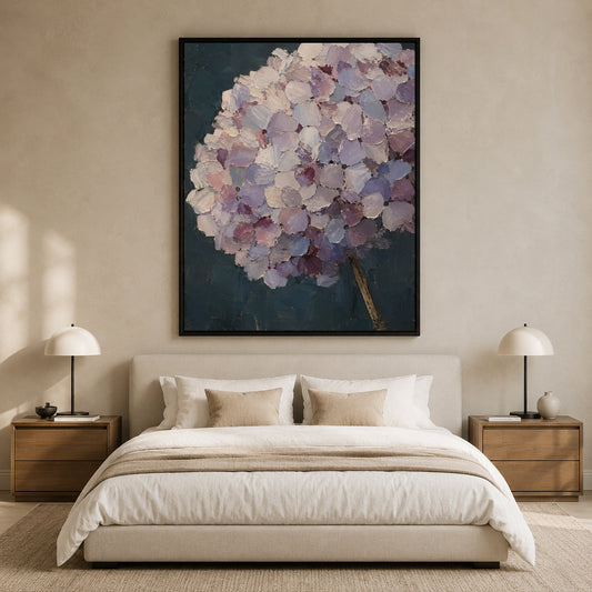 A large framed wall art print featuring a textured purple and lavender hydrangea bouquet on a dark blue background, displayed above a neatly made bed in a modern, neutral-toned bedroom.