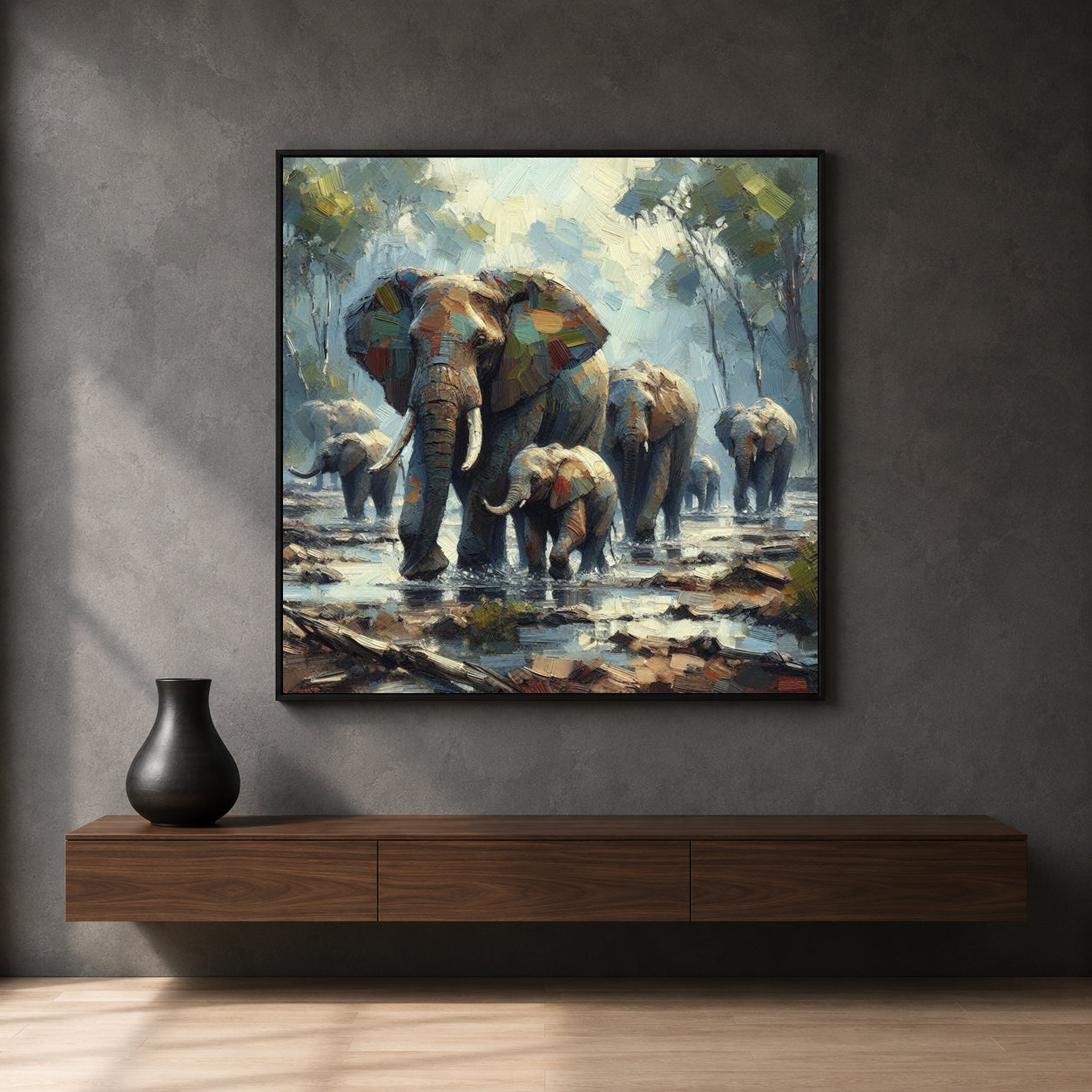 A framed canvas art print depicting a herd of elephants walking through a muddy waterhole, displayed on a dark gray wall above a wooden console table with a black vase.