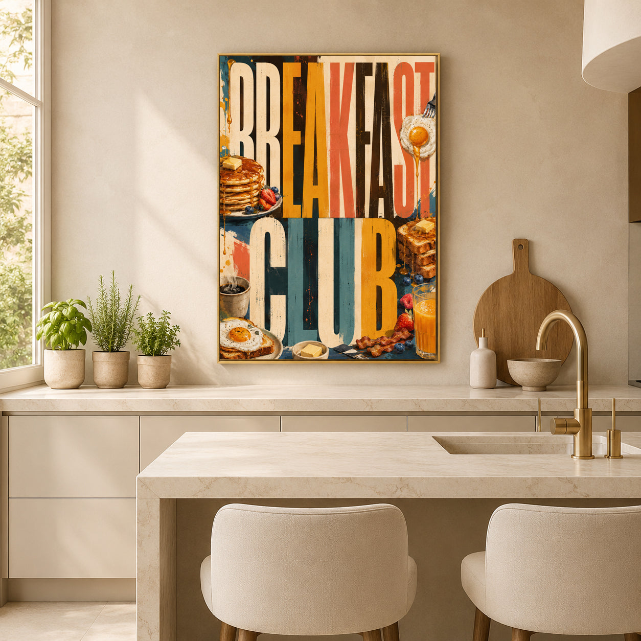 A framed vertical wall art print with the words “BREAKFAST CLUB” in large colorful letters, featuring breakfast food illustrations, hanging on a beige wall in a modern kitchen above a marble island and two upholstered chairs.