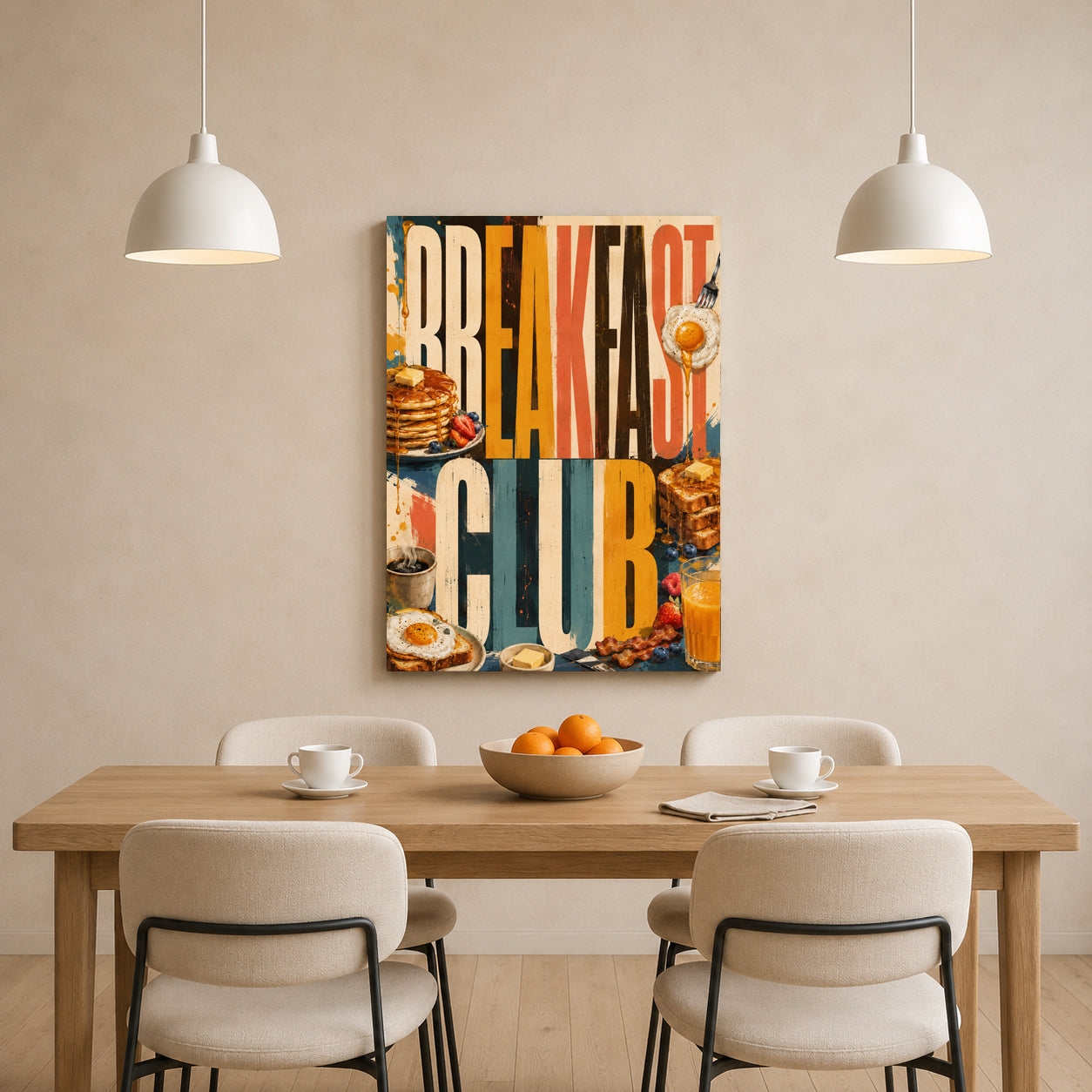 A vertical canvas wall art print featuring retro-style breakfast illustrations and the words “BREAKFAST CLUB,” displayed above a dining table in a modern room setting with chairs, pendant lights, and a bowl of oranges.