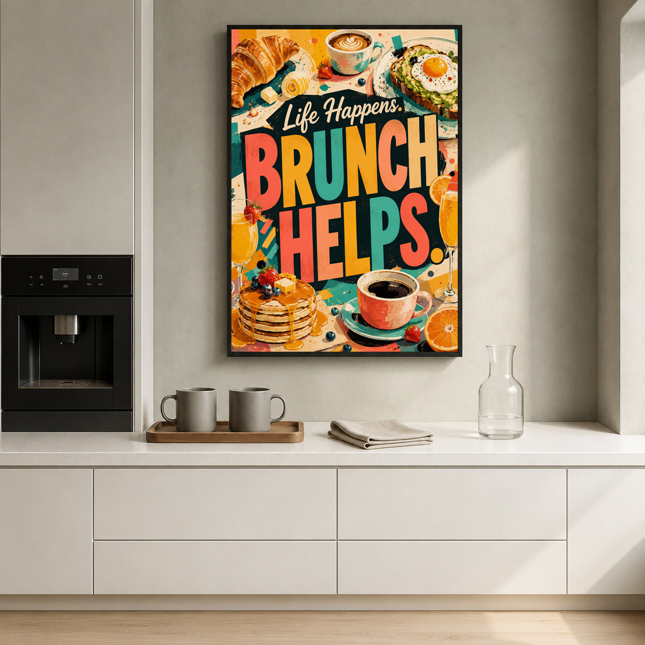 A colorful framed wall art print with the text 'Life Happens BRUNCH HELPS.' hangs on a light gray kitchen wall above a white countertop.