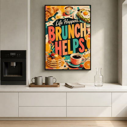 A colorful framed wall art print with the text 'Life Happens BRUNCH HELPS.' hangs on a light gray kitchen wall above a white countertop.