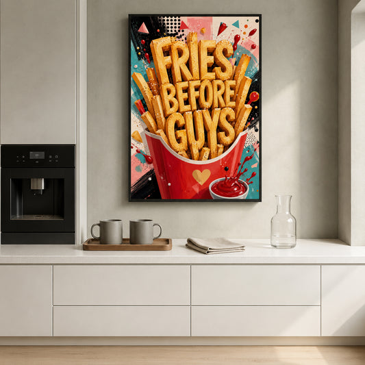 A colorful wall art print featuring the phrase 'FRIES BEFORE GUYS' in large golden letters above a red french fries bucket and ketchup cup, displayed in a modern kitchen setting above a white countertop.