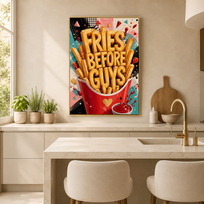 A colorful framed wall art print featuring the text 'FRIES BEFORE GUYS' in large golden letters over a red bucket of fries, displayed above a kitchen island in a bright modern kitchen.