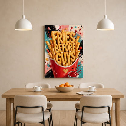 A colorful wall art print featuring the text 'FRIES BEFORE GUYS' in bold lettering, displayed above a wooden dining table with chairs in a modern room setting.