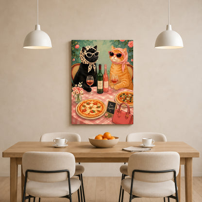 A vertical canvas wall art print depicting a stylish black cat and an orange tabby cat having a dinner party, displayed on a beige wall above a wooden dining table with chairs.
