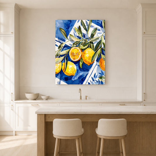 A vertical canvas wall art print featuring a vibrant blue and white watercolor-style background with yellow lemons and green leaves, displayed in a bright, modern kitchen above a counter and two stools.