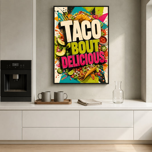 A framed colorful poster with the words 'TACO BOUT DELICIOUS' hangs on a light gray wall above a kitchen counter. The poster features tacos, salsa, guacamole, and other taco ingredients in a bright multicolor design.
