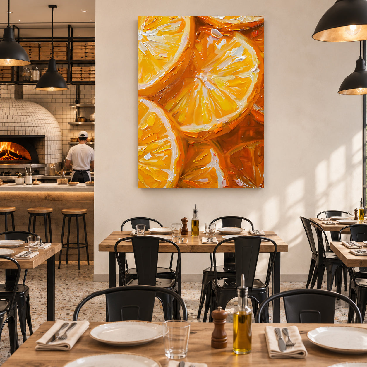 A large vertical canvas print featuring a vibrant orange slice painting, displayed on a white wall in a modern restaurant setting with wooden tables and black chairs.
